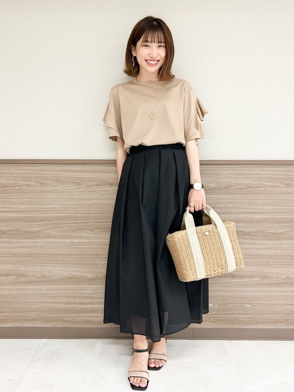 ブラウン系のTシャツ/カットソー、ブラック系のサンダル、ブラック系のスカートを着用したレディースの夏コーディネートの1枚目の写真