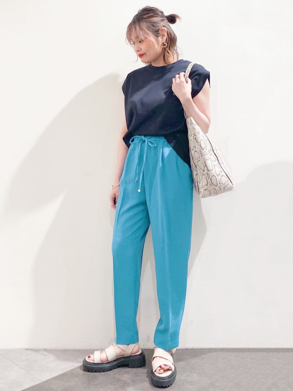 ブラック系のTシャツ/カットソー、ブルー系のその他パンツ、ベージュ系のトートバッグを着用したレディースの春コーディネートの1枚目の写真