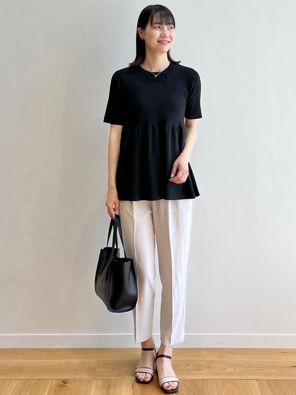 ブラック系のサンダル、グレー系のその他パンツ、ブラック系のトートバッグを着用したレディースの夏コーディネートの1枚目の写真