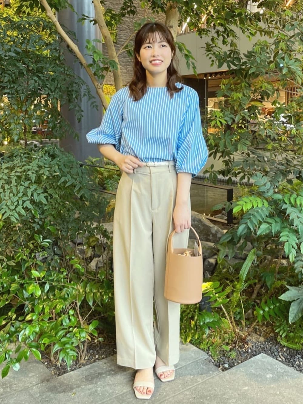 ブルー系のシャツ/ブラウス、ベージュ系のその他パンツ、イエロー系のトートバッグを着用したレディースの春コーディネートの1枚目の写真