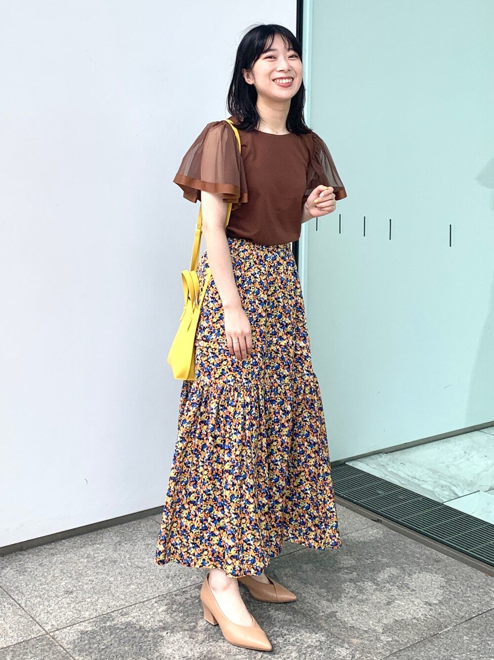 ブラウン系のTシャツ/カットソー、オレンジ系のスカート、イエロー系のショルダーバッグを着用したレディースの夏コーディネートの1枚目の写真