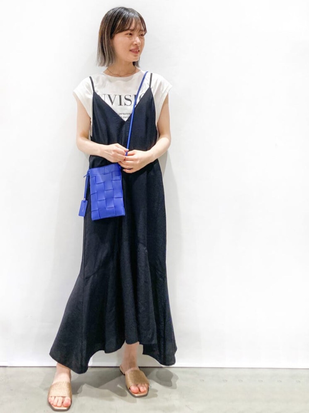 ブラック系のワンピース、ホワイト系のTシャツ/カットソー、ブルー系のショルダーバッグを着用したレディースの夏コーディネートの1枚目の写真