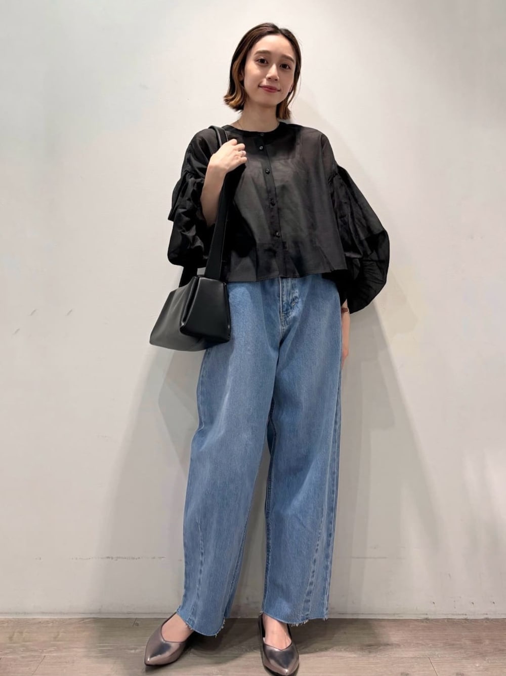 ブラック系のシャツ/ブラウス、シルバー系のパンプス、ブルー系のデニムパンツを着用したレディースの夏コーディネートの1枚目の写真
