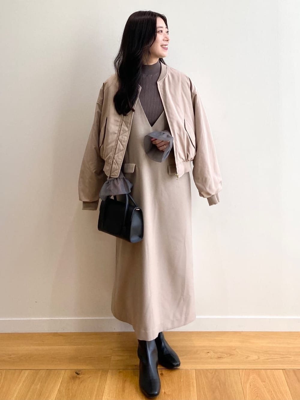 ベージュ系のブルゾン、グレー系のニット/セーター、ブラック系のブーツを着用したレディースの冬コーディネートの1枚目の写真