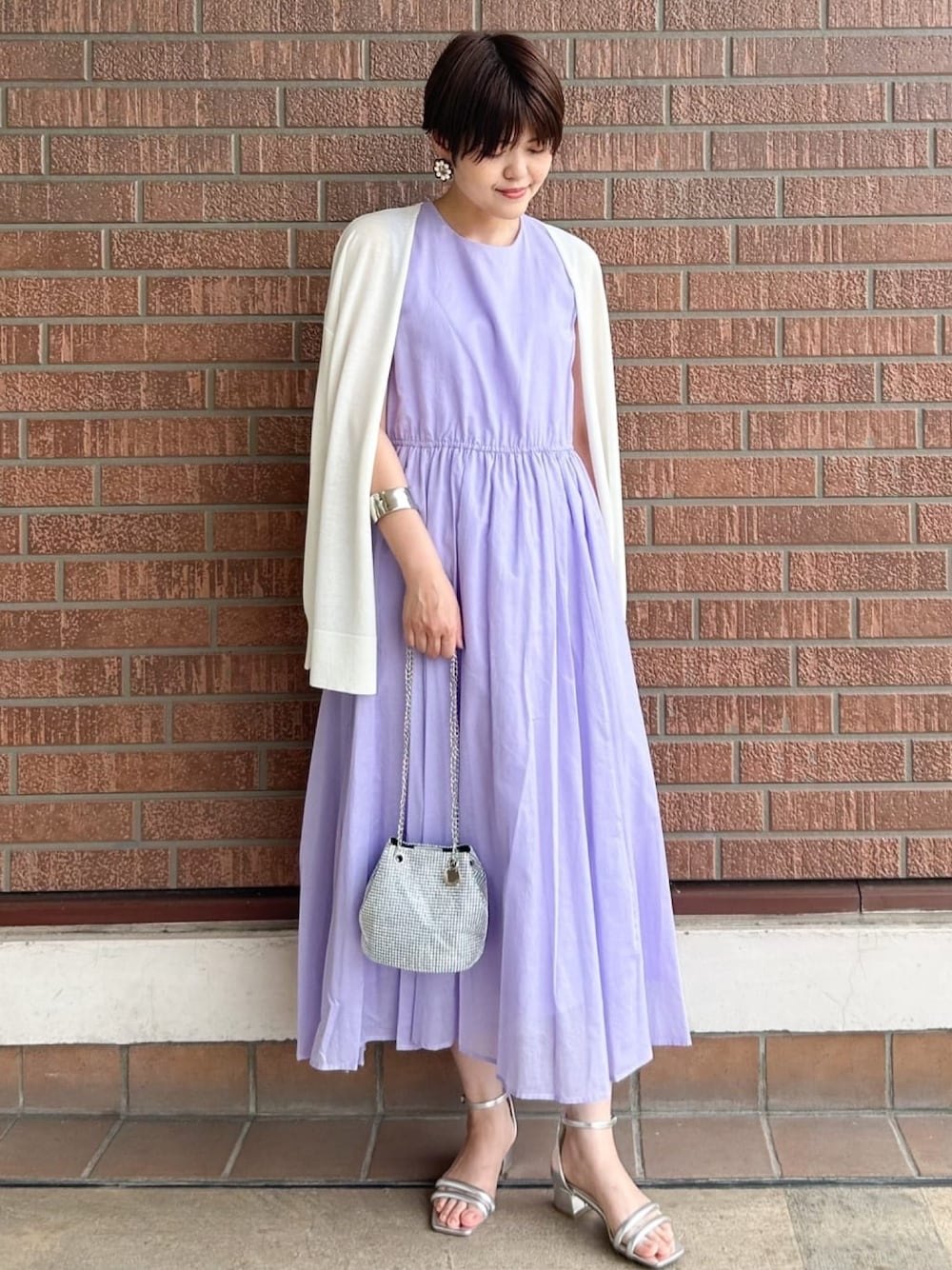 ホワイト系のカーディガン/ボレロ、パープル系のワンピース、ホワイト系のショルダーバッグを着用したレディースの夏コーディネートの1枚目の写真