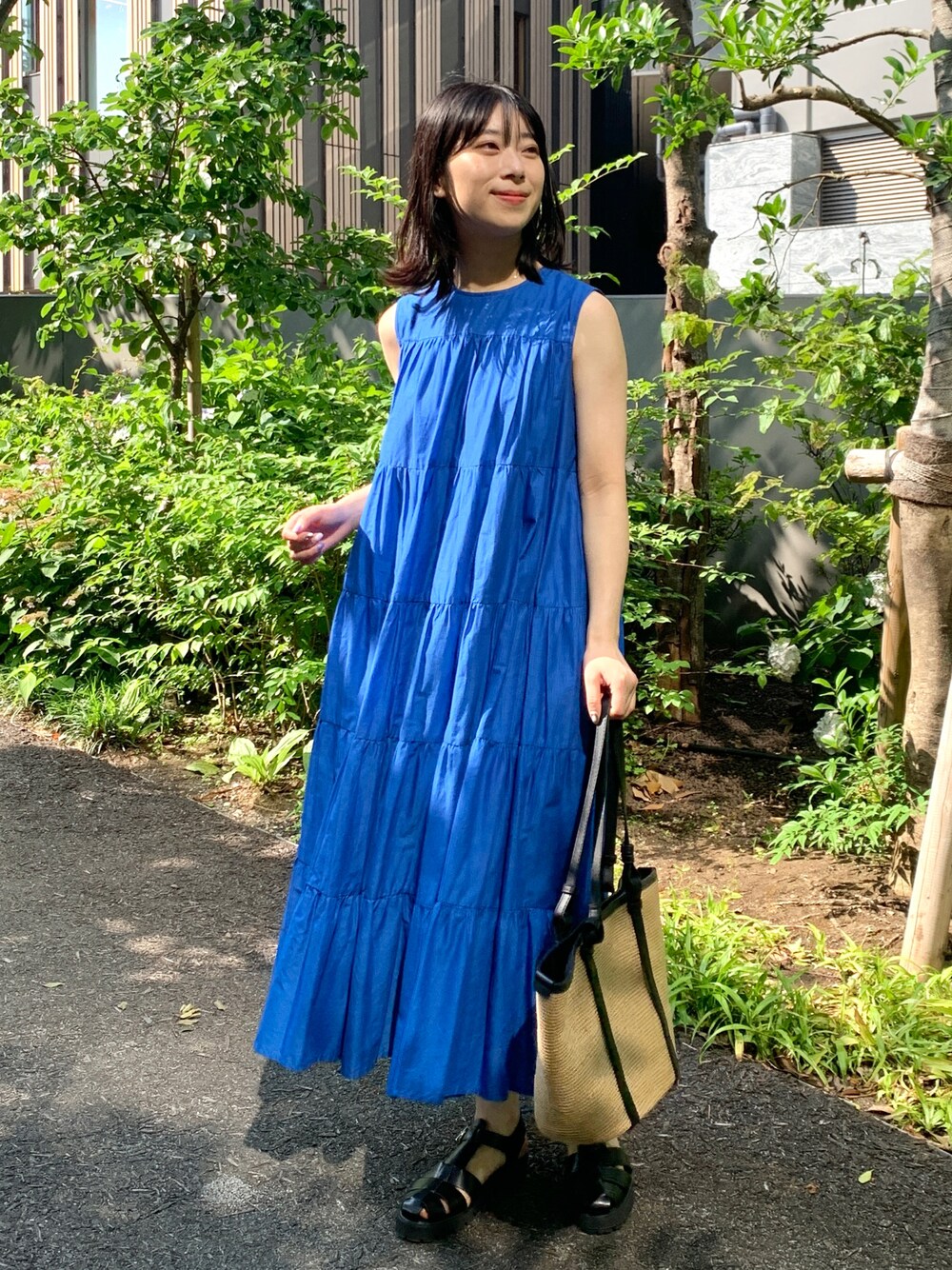 ブルー系のワンピース、ブラック系のサンダル、ブラック系のトートバッグを着用したレディースの夏コーディネートの1枚目の写真