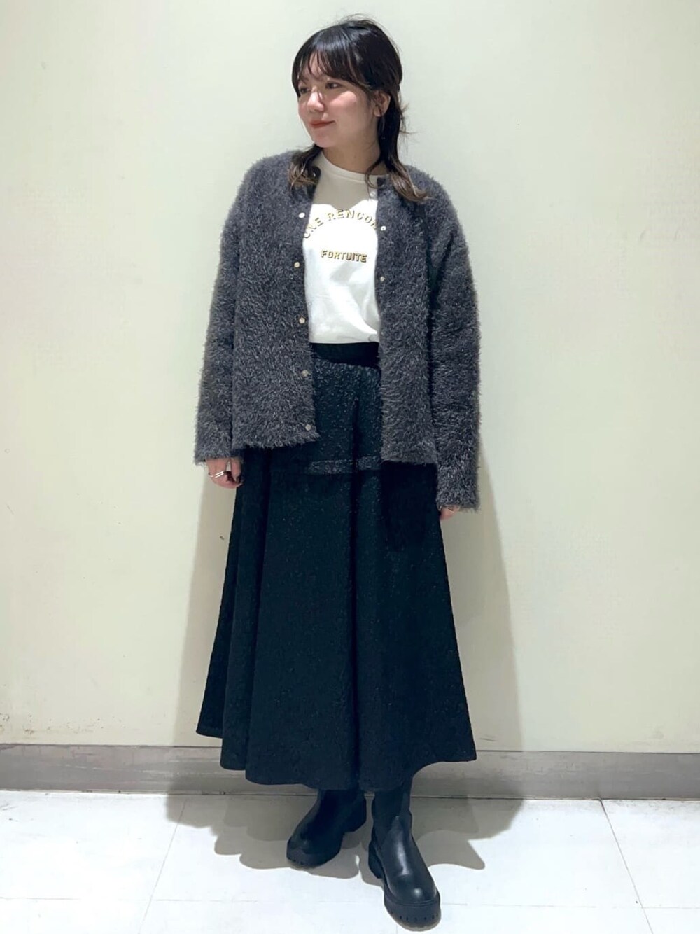 ブラック系のスカート、ブラック系のブーツ、グレー系のカーディガン/ボレロを着用したレディースの秋コーディネートの1枚目の写真