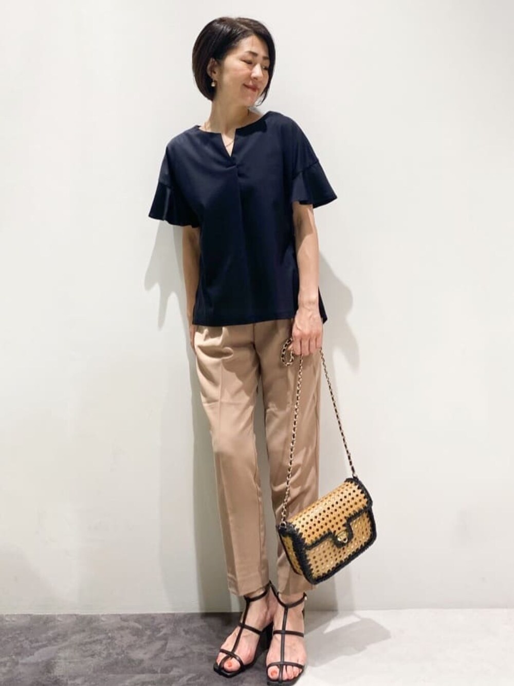 ブラック系のTシャツ/カットソー、ブラック系のショルダーバッグ、ブラック系のサンダルを着用したレディースの夏コーディネートの1枚目の写真