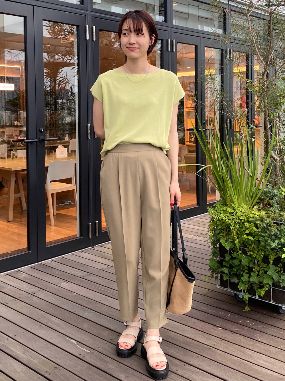 グリーン系のニット/セーター、ベージュ系のその他パンツ、ホワイト系のサンダルを着用したレディースの夏コーディネートの1枚目の写真