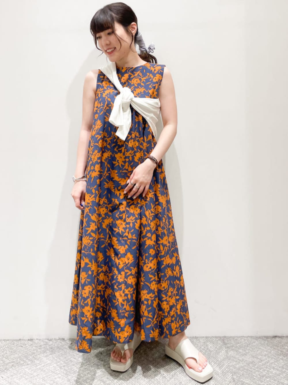 ブルー系のワンピース、ホワイト系のサンダル、ホワイト系のカーディガン/ボレロを着用したレディースの夏コーディネートの1枚目の写真