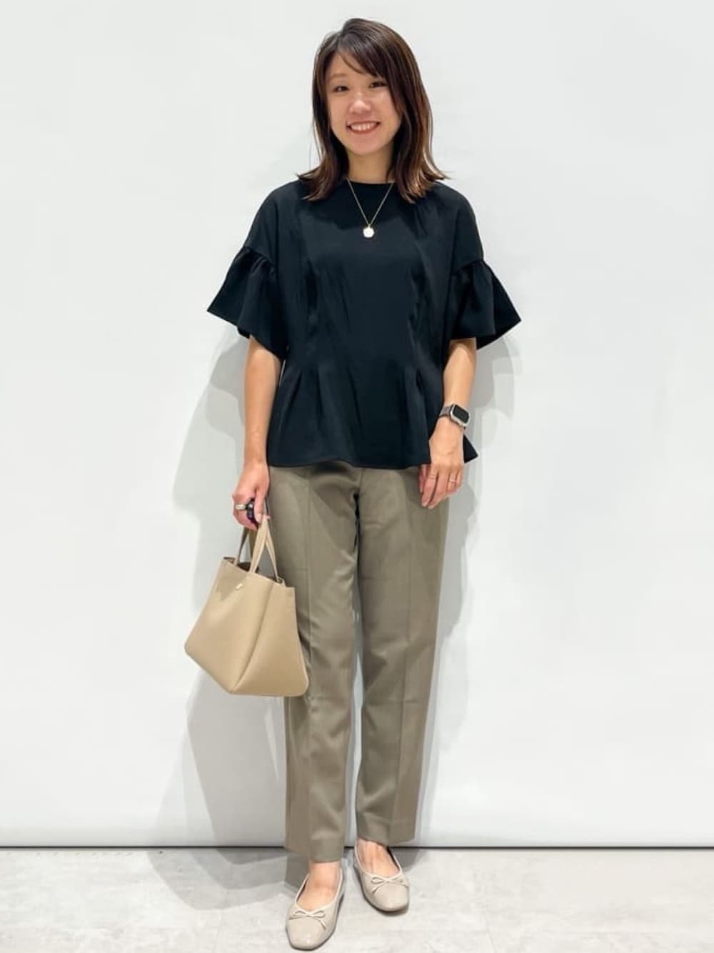 ブラック系のシャツ/ブラウス、ベージュ系のその他パンツ、ベージュ系のトートバッグを着用したレディースの秋コーディネートの1枚目の写真