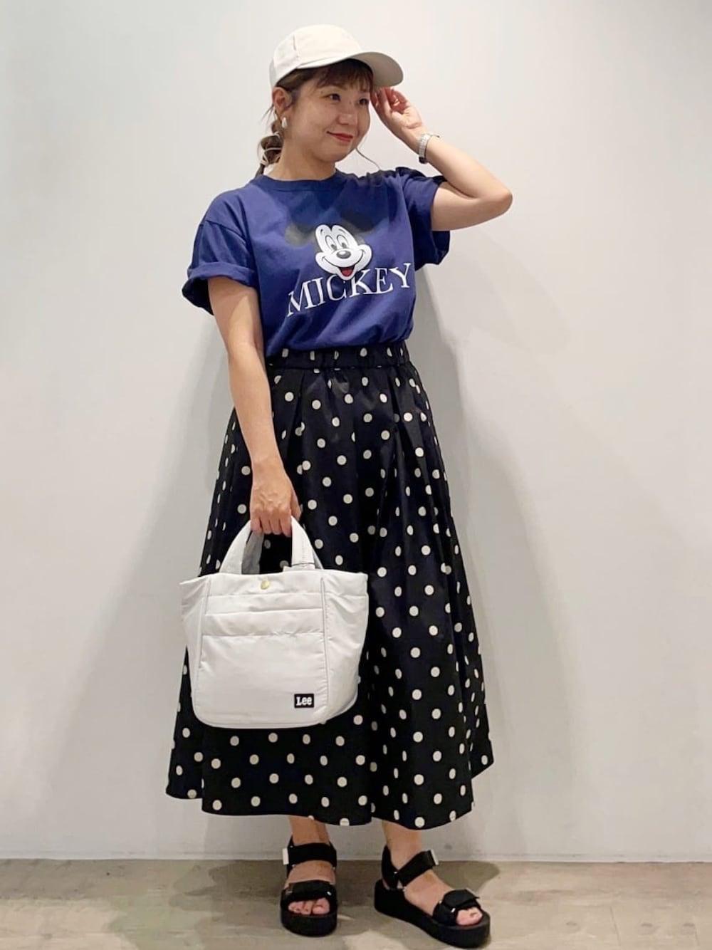 ブルー系のTシャツ/カットソー、ブラック系のスカート、グレー系のトートバッグを着用したレディースの夏コーディネートの1枚目の写真