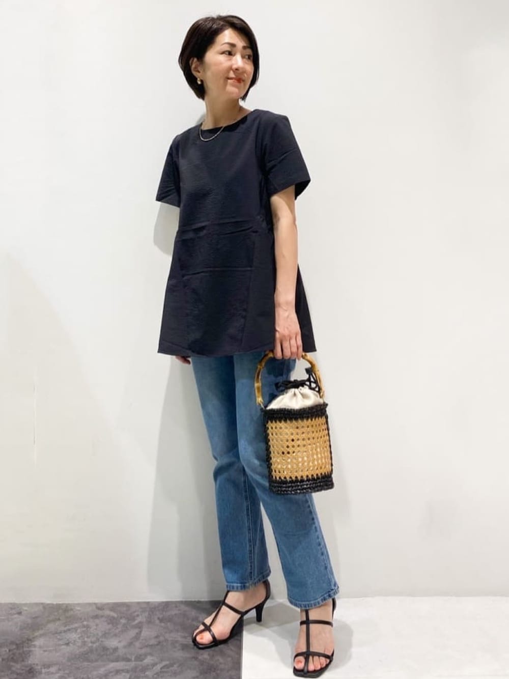 ブラック系のシャツ/ブラウス、ブルー系のデニムパンツ、ブラック系のトートバッグを着用したレディースの夏コーディネートの1枚目の写真