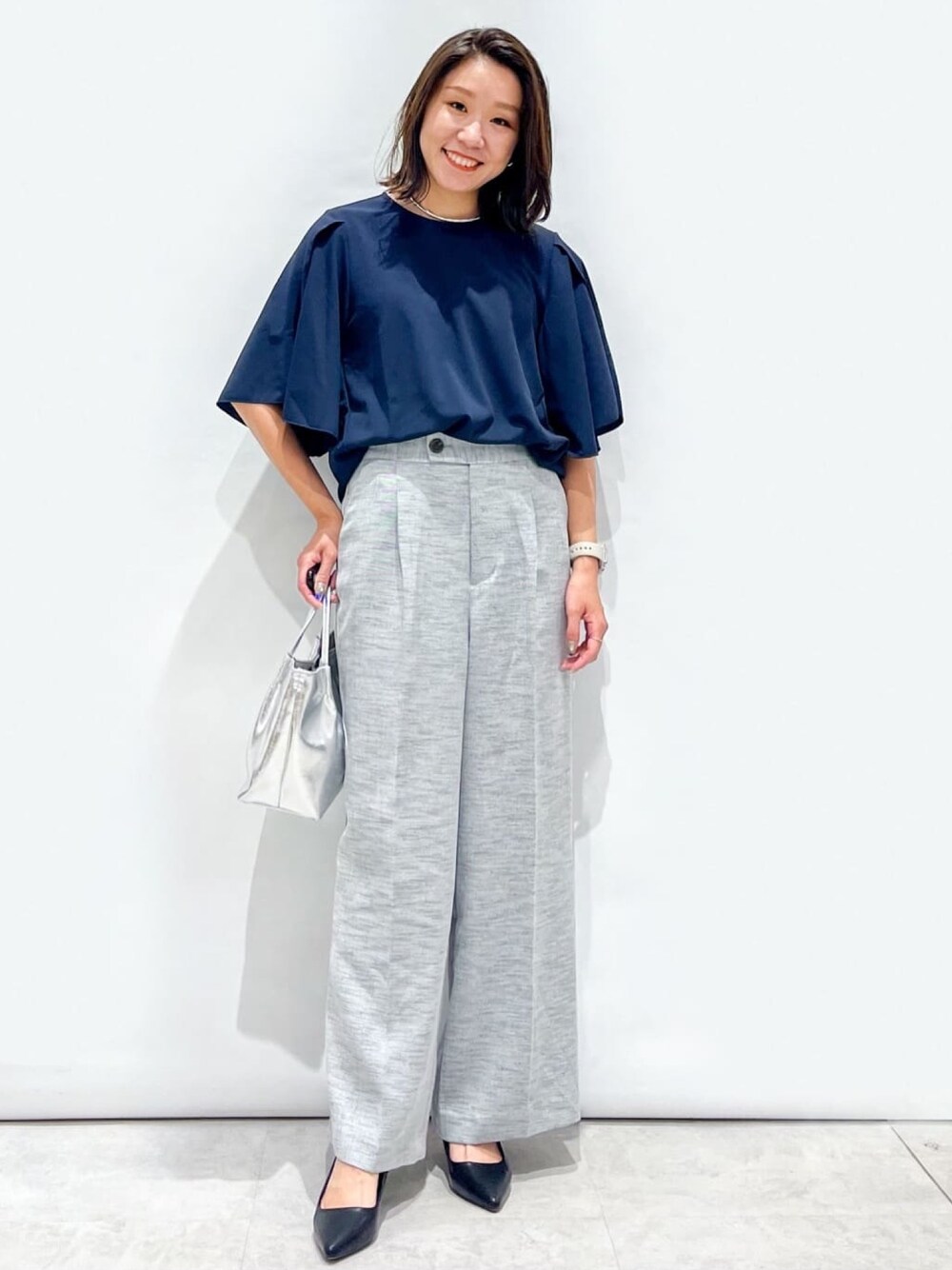 ブラック系のその他パンツ、ブラック系のパンプス、シルバー系のトートバッグを着用したレディースの夏コーディネートの1枚目の写真