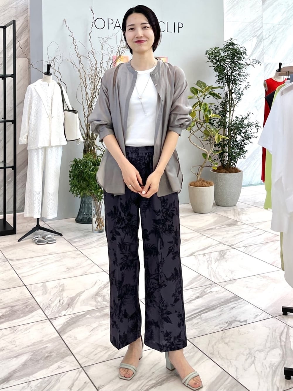 グレー系のその他パンツ、グリーン系のサンダル、グレー系のシャツ/ブラウスを着用したレディースの春コーディネートの1枚目の写真