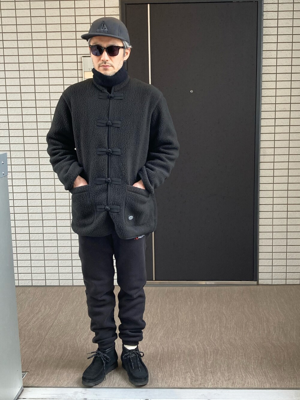 「ブラックコーデ、ワントーンコーデ、オールブラック、フリース、チャイナジャケット、フリースジャケット、フリースパンツ、キャップ、サングラス、タートルネックニット、clarks、GORE-TEX、大人カジュアル、大人コーデ、今日のコーデ」｜「NIKE ACGのアイテム（キャップ、ブラック系）」を使った、toshiさん（メンズ・168cm）の春コーディネートの1枚目の写真