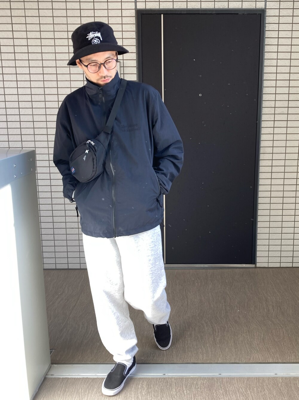 「スウェットパンツ、スウェット、VANS、stussy、大人カジュアル、スポーツミックス、スリッポン、ナイロンジャケット、ootd、メガネ男子、バケットハット、ウエストポーチ、ゆるコーデ、ストリートコーデ、秋コーデ」｜「STUSSYのアイテム（ハット、ブラック系）」を使った、toshiさん（メンズ・168cm）の秋コーディネートの1枚目の写真
