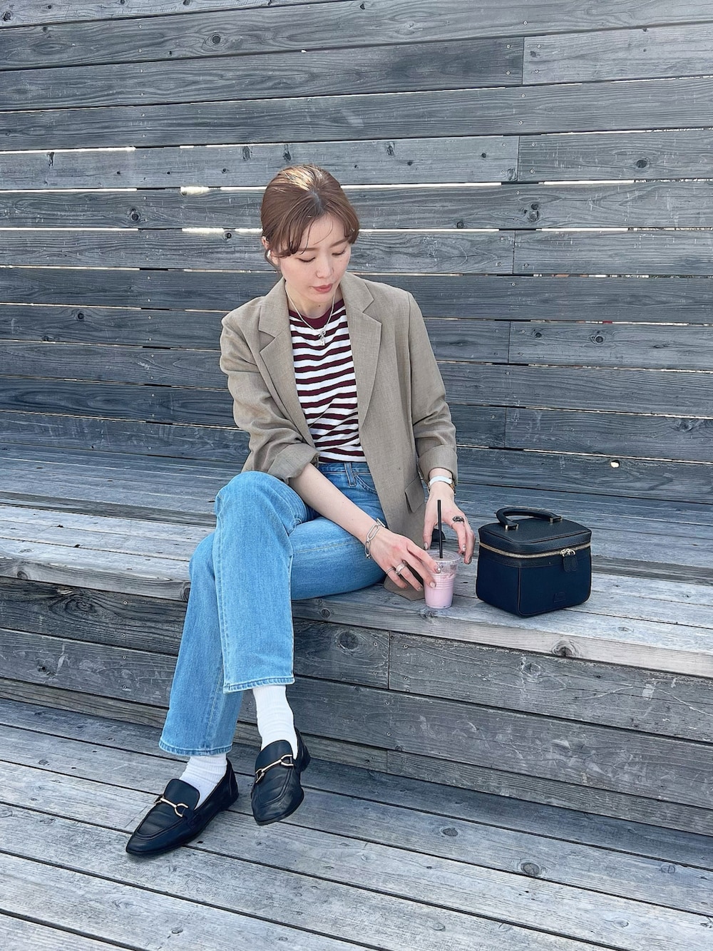 ブルー系のデニムパンツ、レッド系のTシャツ/カットソー、ブラック系のローファーを着用したレディースの春コーディネートの1枚目の写真