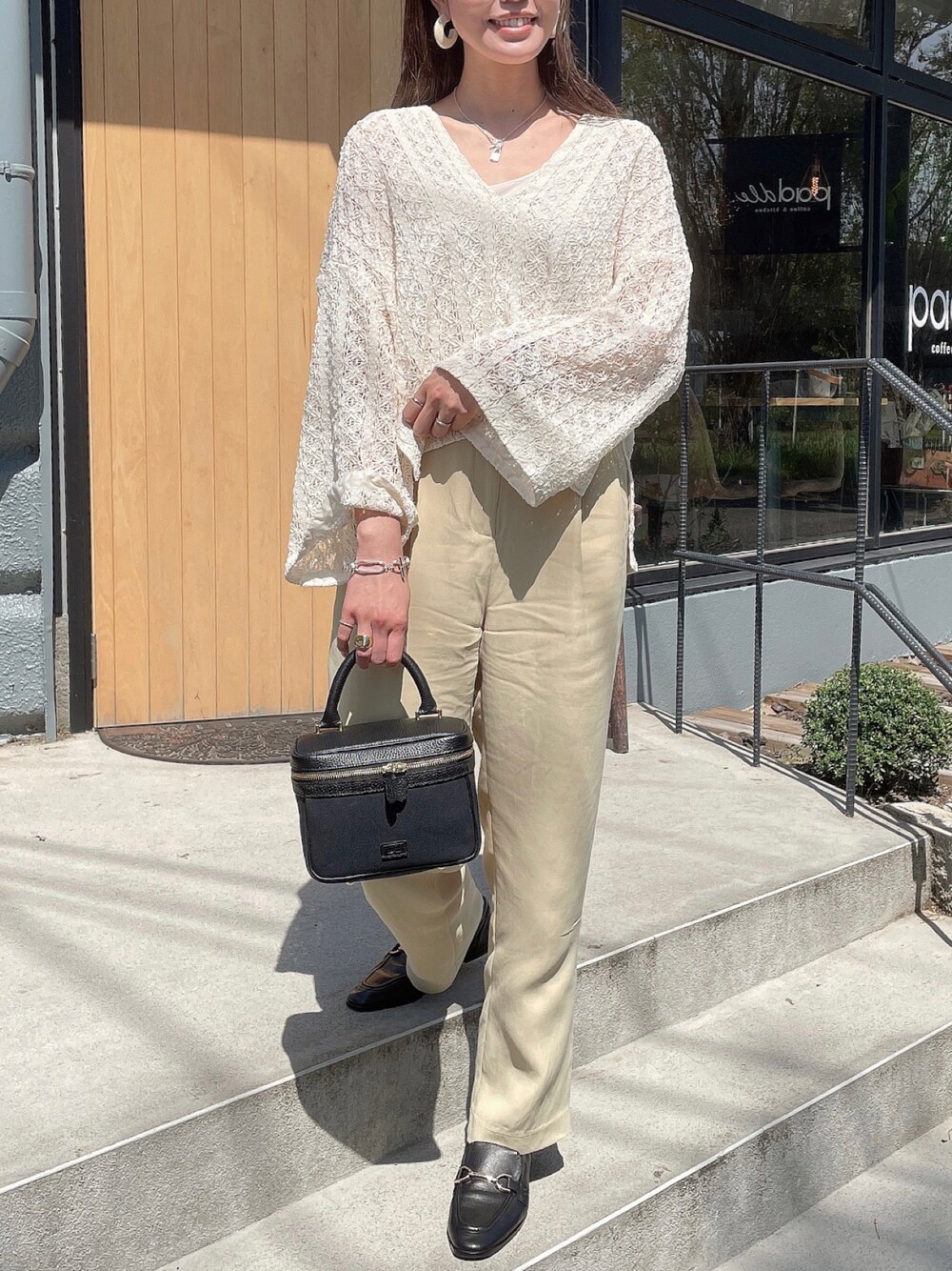 ブラック系のハンドバッグ、ベージュ系のその他パンツ、ホワイト系のトップスを着用したレディースの秋コーディネートの1枚目の写真