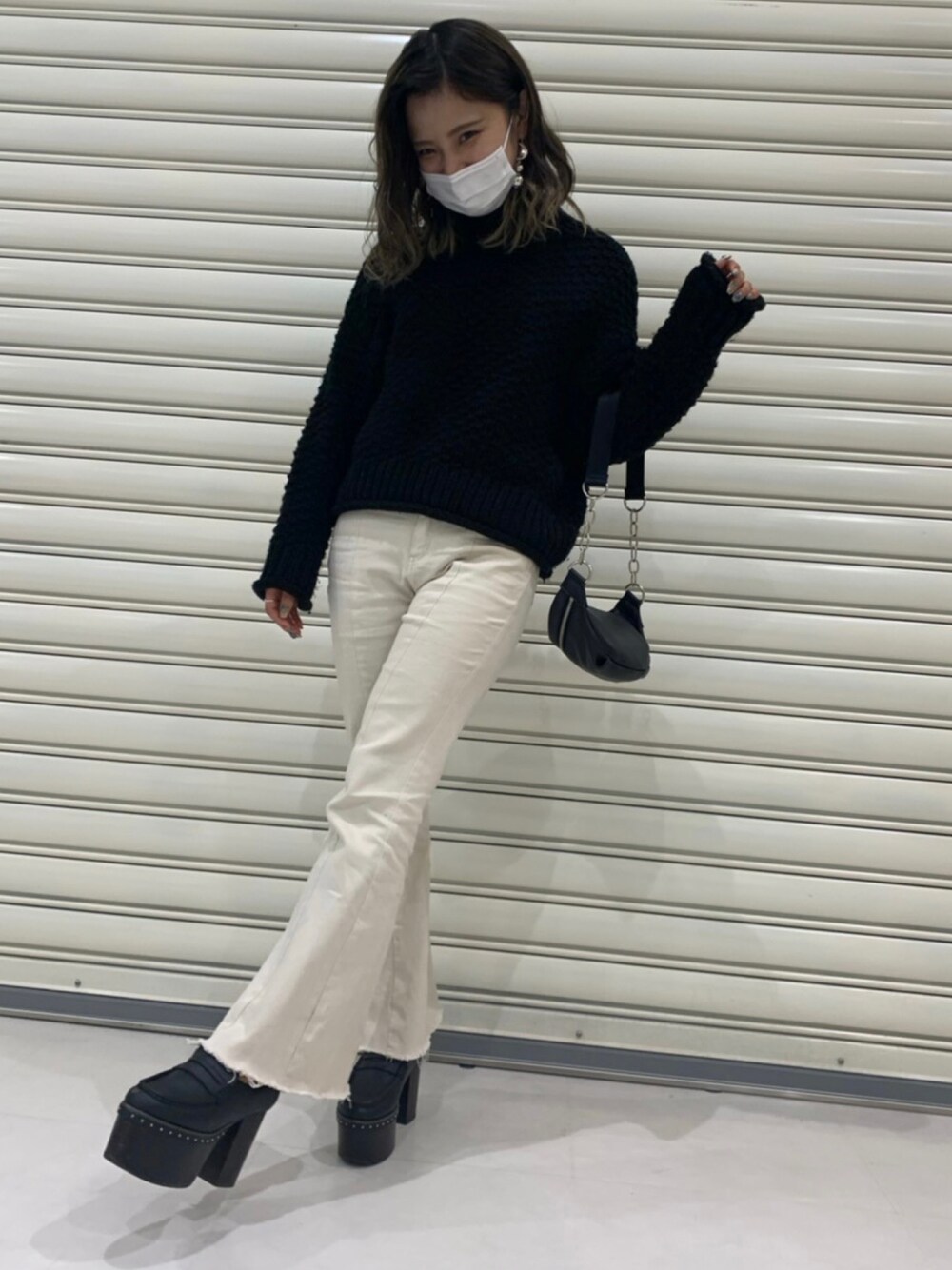 ブラック系のニット/セーター、ホワイト系のその他パンツ、ブラック系のボディバッグ/ウエストポーチを着用したレディースの秋コーディネートの1枚目の写真