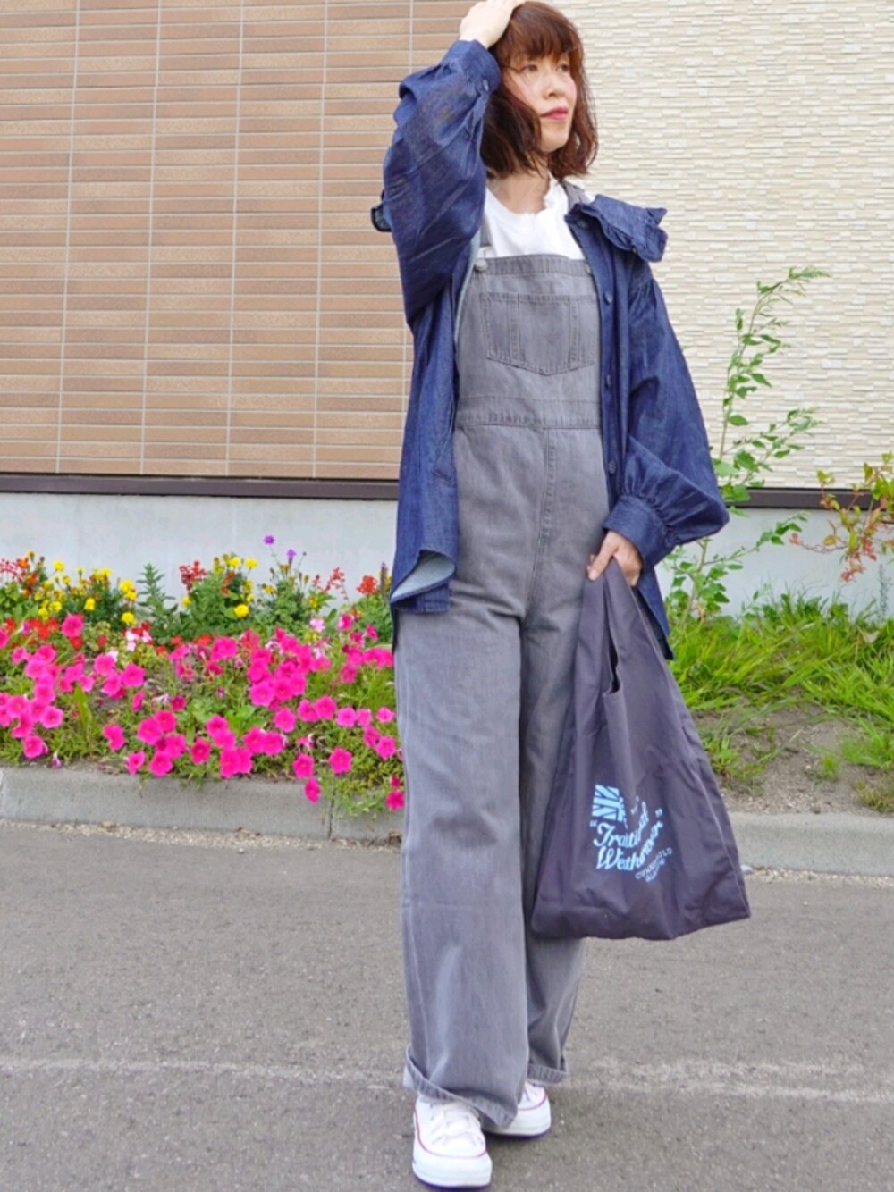 ブルー系のデニムジャケット、グレー系のサロペット/オーバーオール、グレー系のトートバッグを着用したレディースの秋コーディネートの1枚目の写真