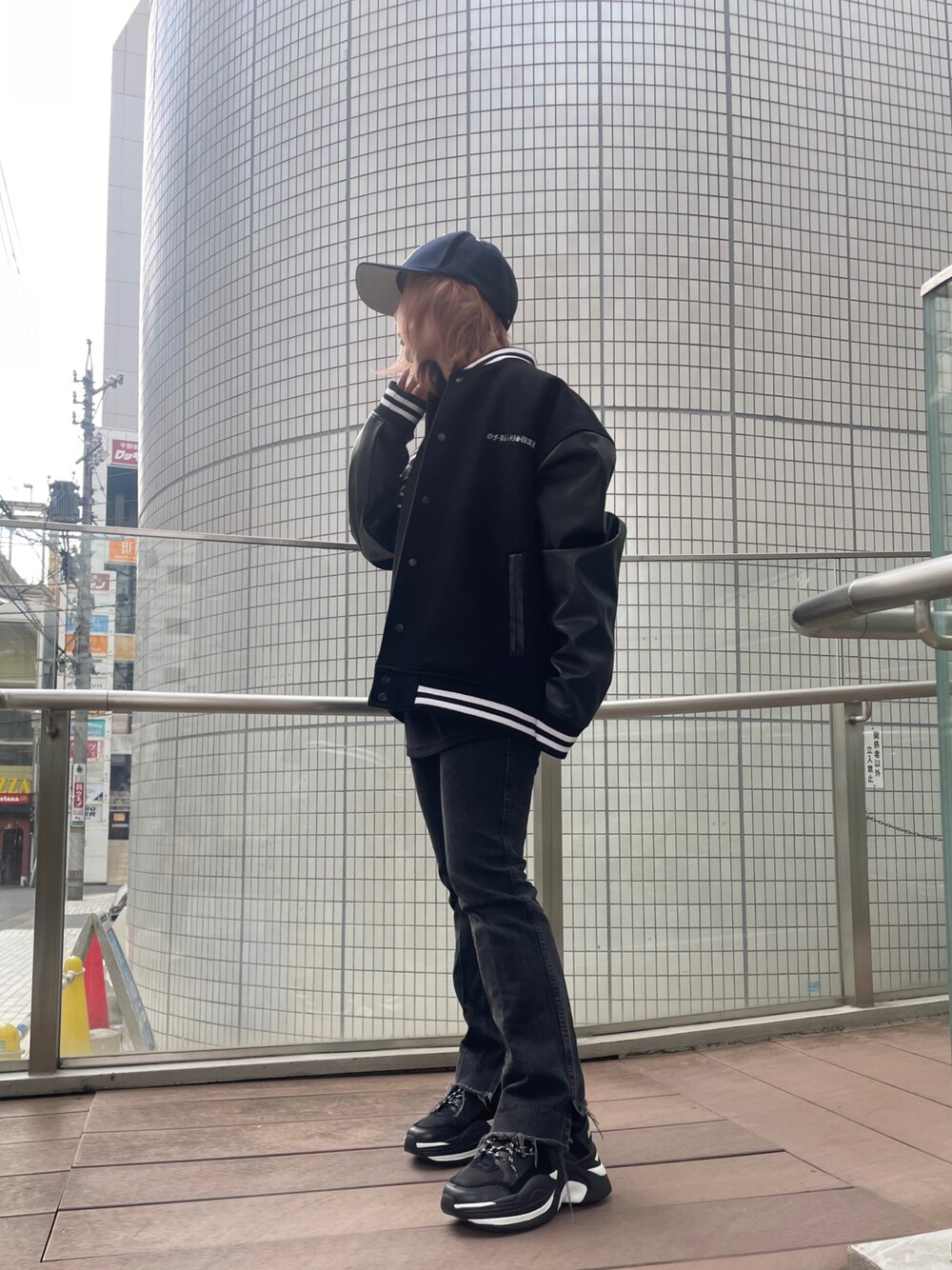 ブラック系のスニーカー、ブラック系のブルゾン、ブラック系のスタジャンを着用したレディースの秋コーディネートの1枚目の写真