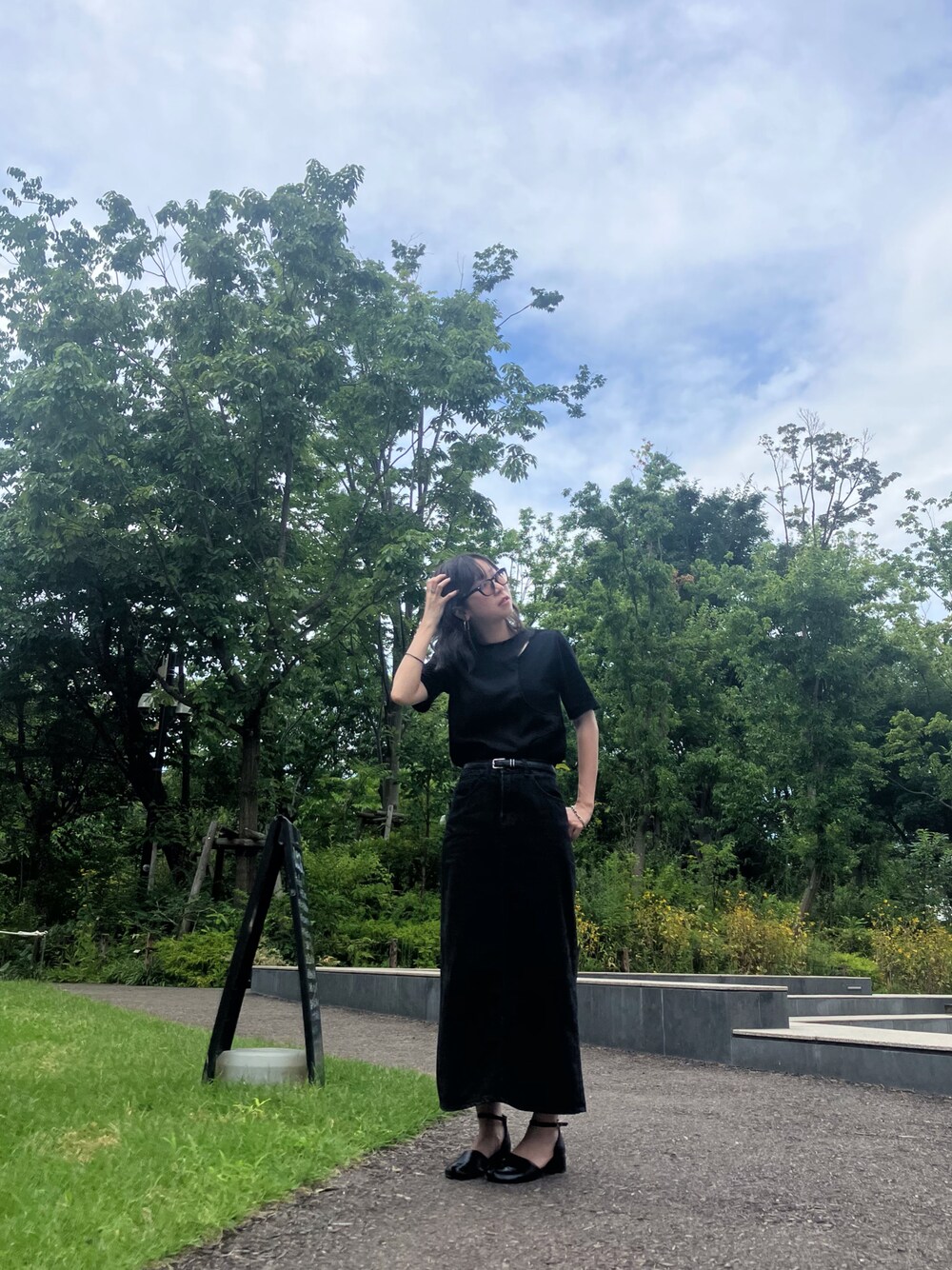 ブラック系のTシャツ/カットソー、ブラック系のサンダルを着用したレディースの夏コーディネートの1枚目の写真