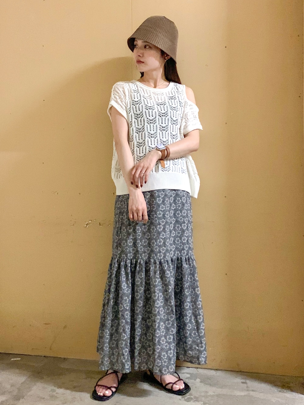 ベージュ系のベスト、グレー系のスカート、ホワイト系の音楽/本・雑誌を着用したレディースの夏コーディネートの1枚目の写真
