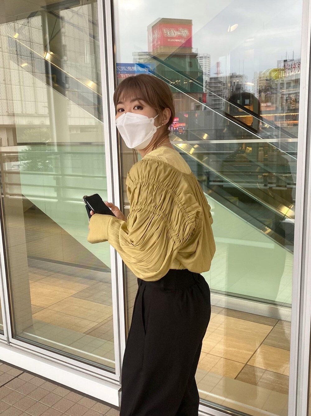 イエロー系のシャツ/ブラウス、イエロー系のニット/セーター、ブラック系のその他パンツを着用したレディースの春コーディネートの3枚目の写真