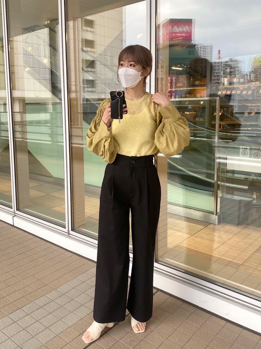 イエロー系のシャツ/ブラウス、イエロー系のニット/セーター、ブラック系のその他パンツを着用したレディースの春コーディネートの2枚目の写真