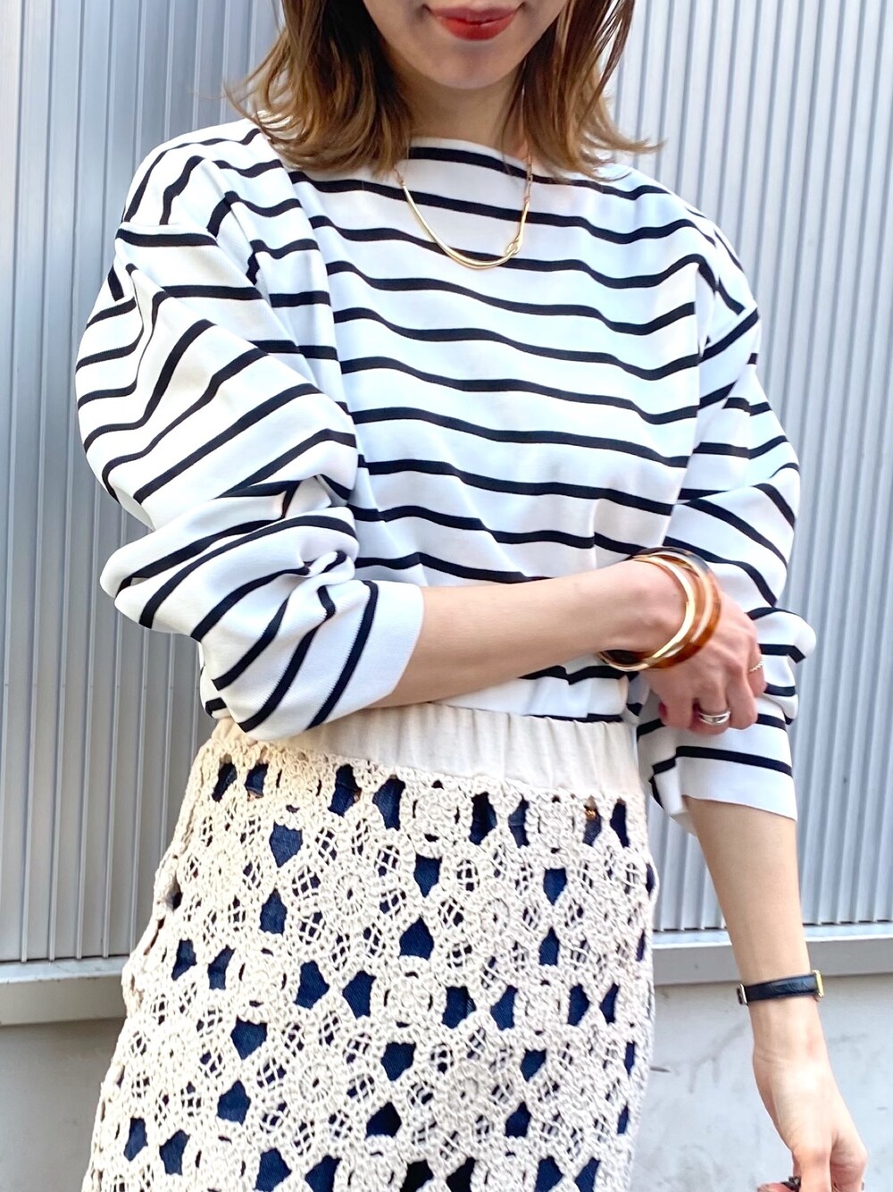 ブラック系のニット/セーター、ホワイト系のスカート、ブルー系のデニムパンツを着用したレディースの冬コーディネートの3枚目の写真