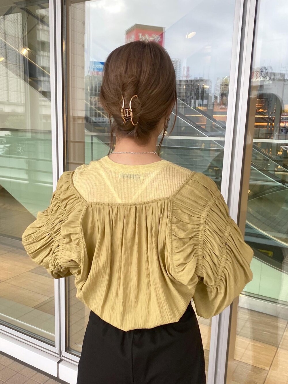 イエロー系のシャツ/ブラウス、イエロー系のニット/セーター、ブラック系のその他パンツを着用したレディースの春コーディネートの5枚目の写真