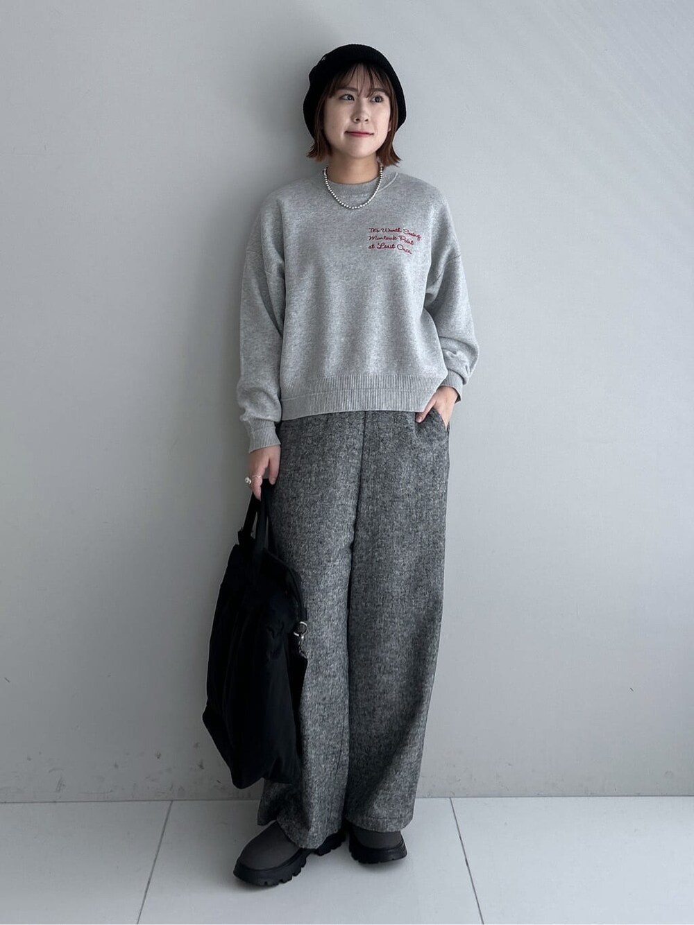 グレー系のニット/セーター、ブラック系のその他パンツ、ブラック系のダウンジャケット/コートを着用したレディースの秋コーディネートの1枚目の写真
