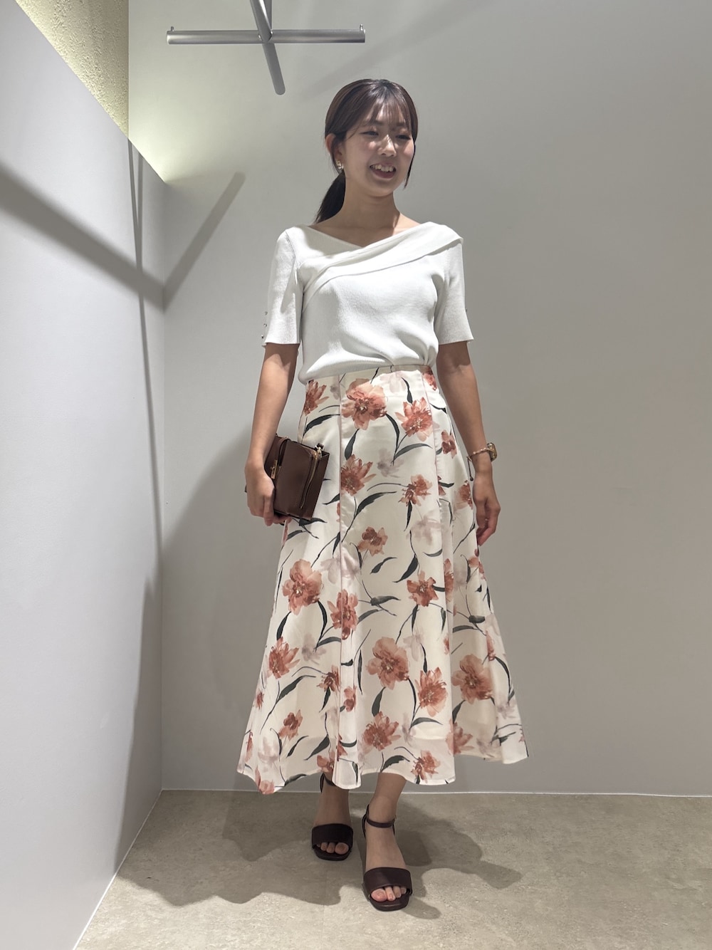 ホワイト系のニット/セーター、ベージュ系のスカート、ブラウン系のサンダルを着用したレディースの夏コーディネートの1枚目の写真
