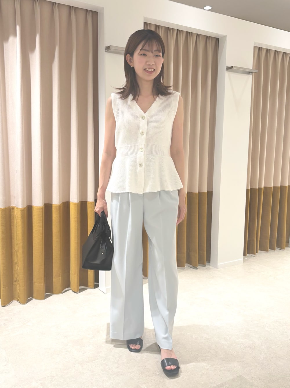 ホワイト系のベスト、ブルー系のその他パンツ、ブラック系のサンダルを着用したレディースの夏コーディネートの1枚目の写真