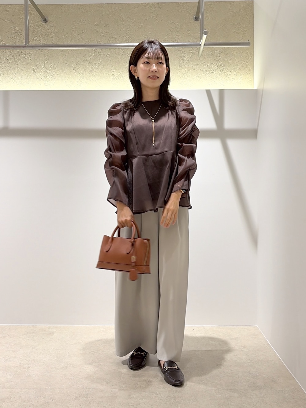 ブラウン系のシャツ/ブラウス、ベージュ系のその他パンツ、ブラック系のトートバッグを着用したレディースの秋コーディネートの1枚目の写真