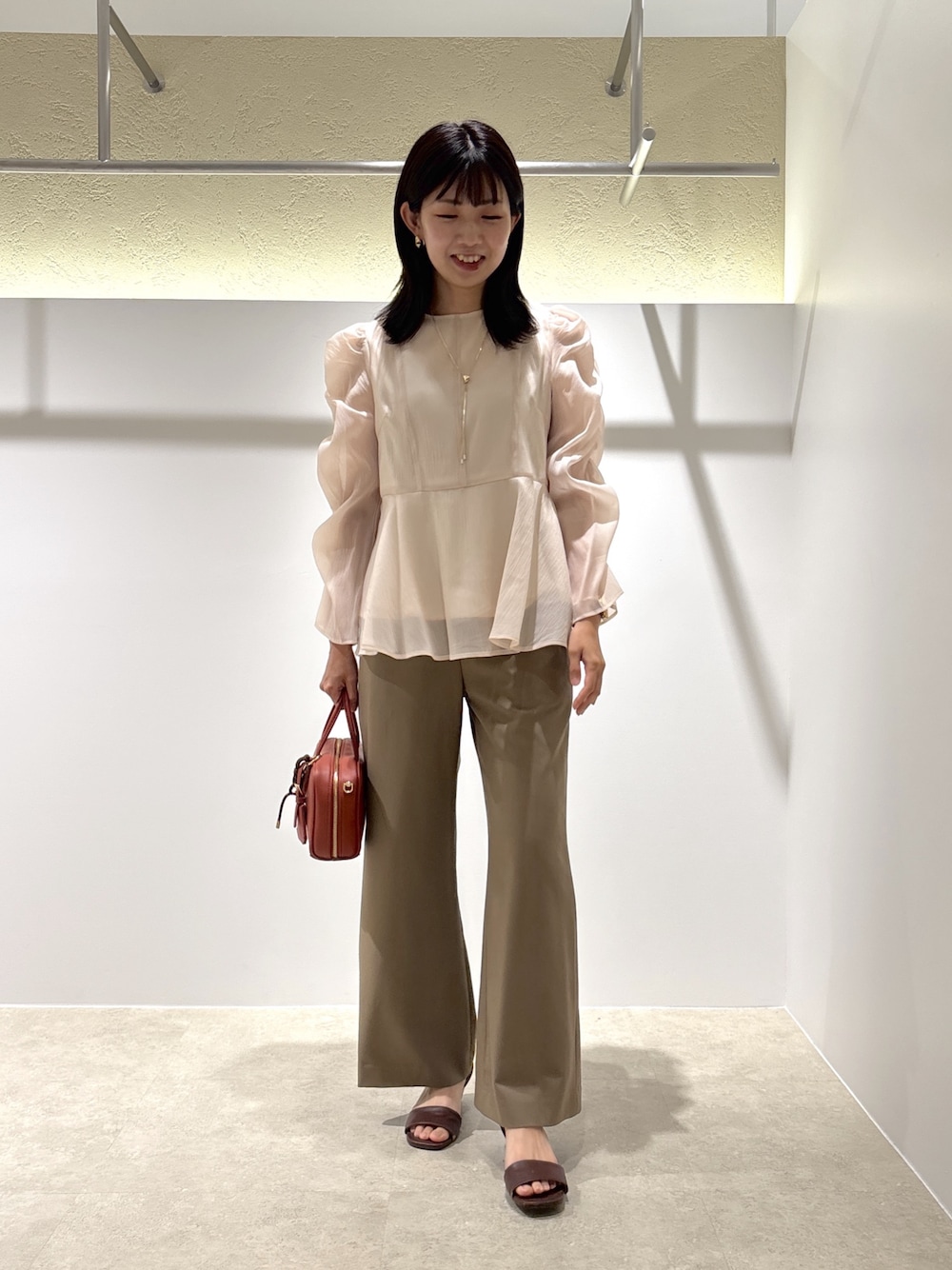 ベージュ系のシャツ/ブラウス、イエロー系のその他パンツ、ブラウン系のサンダルを着用したレディースの秋コーディネートの1枚目の写真