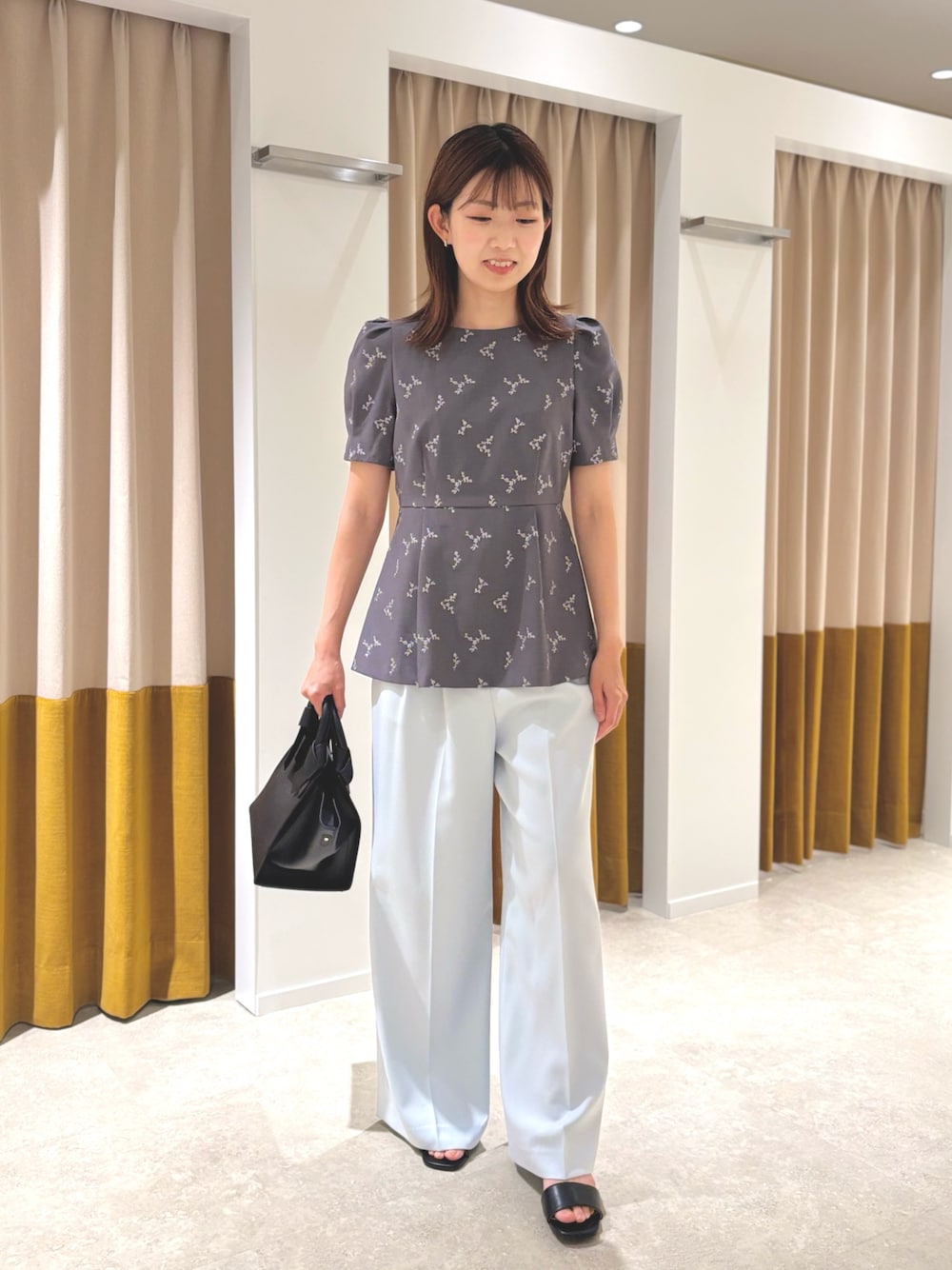 グレー系のシャツ/ブラウス、ブラック系のトートバッグ、ブラック系のサンダルを着用したレディースの夏コーディネートの1枚目の写真