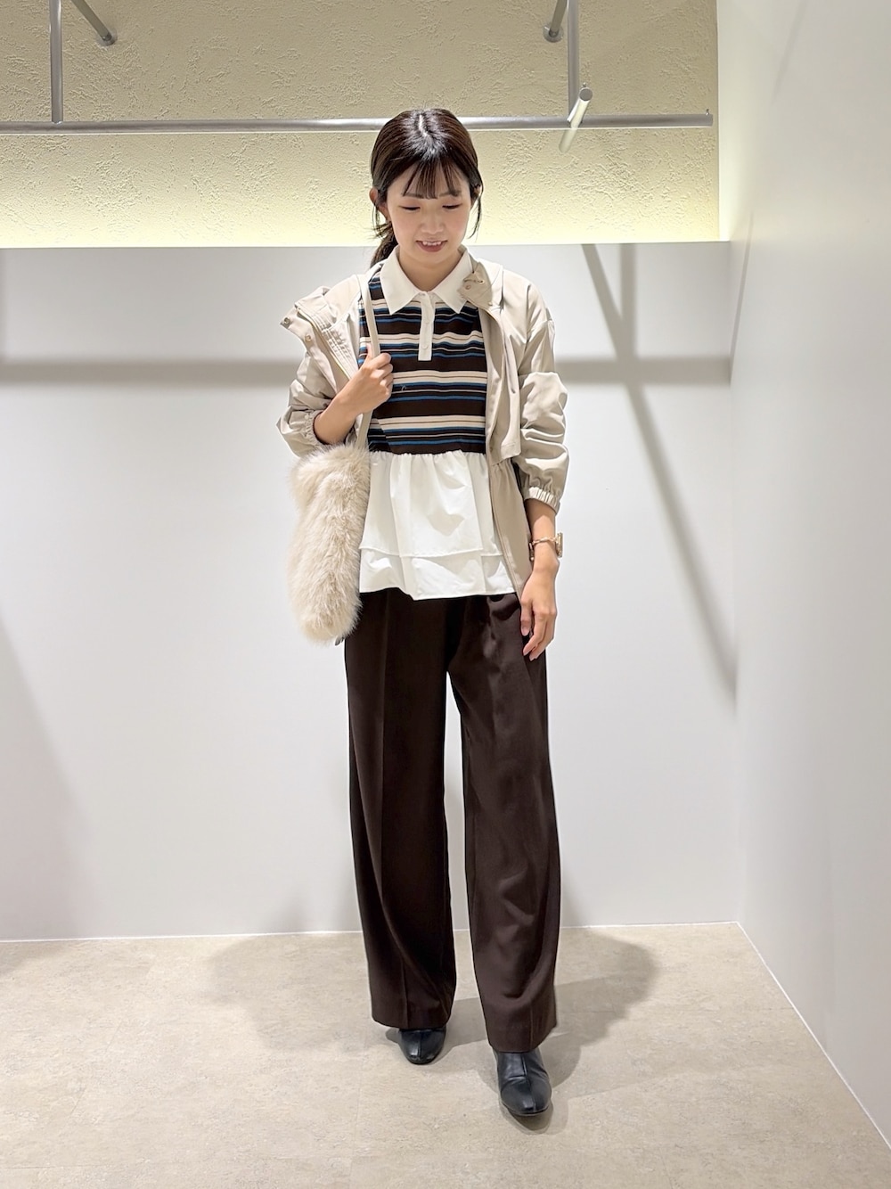 ベージュ系のマウンテンパーカー、ブラウン系のニット/セーター、ブラウン系のブーツを着用したレディースの秋コーディネートの1枚目の写真