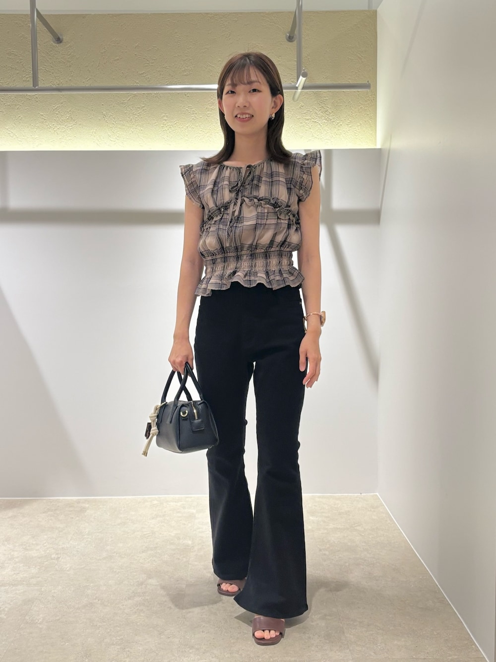 ベージュ系のシャツ/ブラウス、ブラック系のデニムパンツ、ブラック系のボストンバッグを着用したレディースの夏コーディネートの1枚目の写真