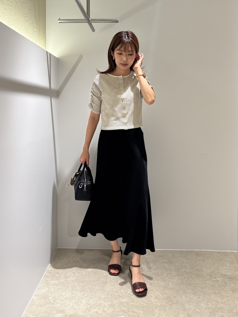 ホワイト系のTシャツ/カットソー、ブラウン系のサンダル、ブラック系のボストンバッグを着用したレディースの夏コーディネートの1枚目の写真