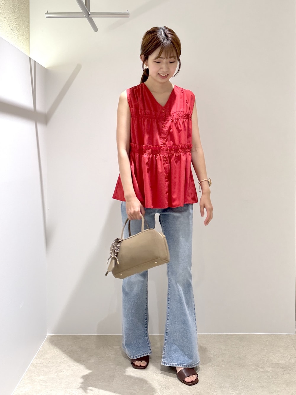 レッド系のシャツ/ブラウス、ブルー系のデニムパンツ、ブラック系のボストンバッグを着用したレディースの夏コーディネートの1枚目の写真