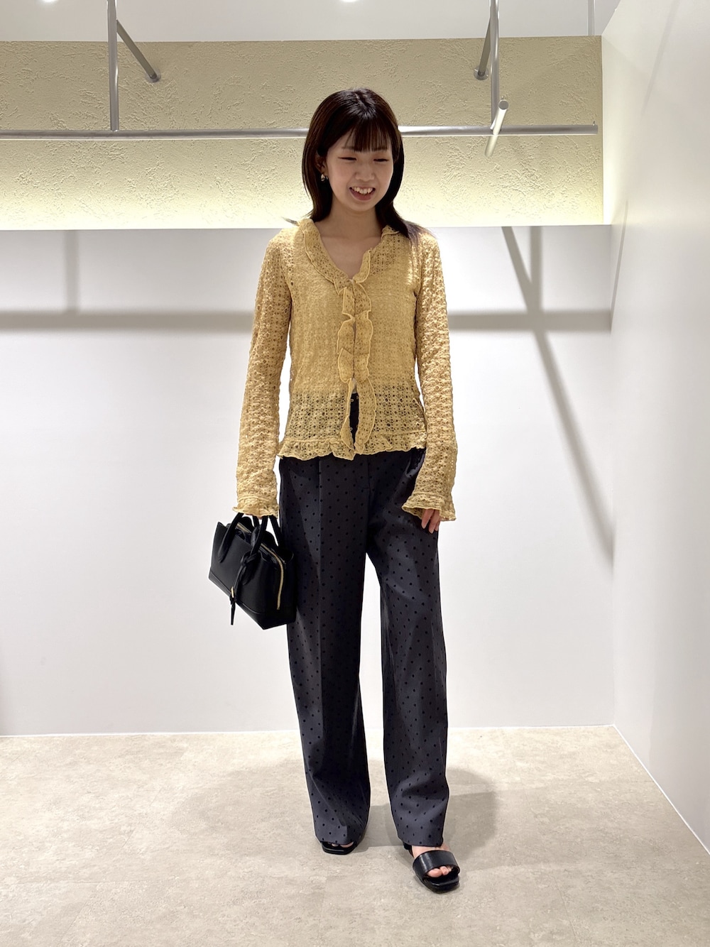 イエロー系のカーディガン/ボレロ、グレー系のその他パンツ、ブラック系のサンダルを着用したレディースの夏コーディネートの1枚目の写真