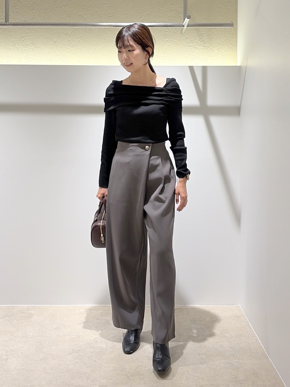 ブラック系のニット/セーター、グレー系のその他パンツ、ブラウン系のブーツを着用したレディースの秋コーディネートの1枚目の写真