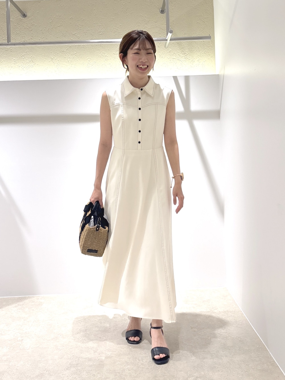 ホワイト系のワンピース、ブラック系のサンダル、ベージュ系のかごバッグを着用したレディースの夏コーディネートの1枚目の写真