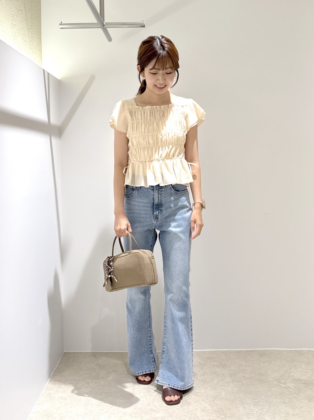 ピンク系のシャツ/ブラウス、ブルー系のデニムパンツ、ブラック系のボストンバッグを着用したレディースの夏コーディネートの1枚目の写真