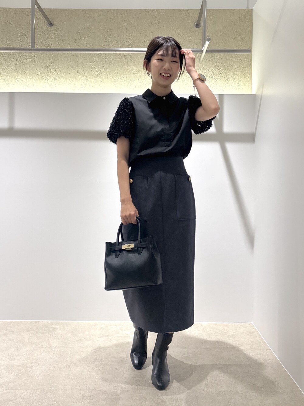 ブラック系のシャツ/ブラウス、ブラック系のトートバッグ、ブラック系のブーツを着用したレディースの夏コーディネートの1枚目の写真