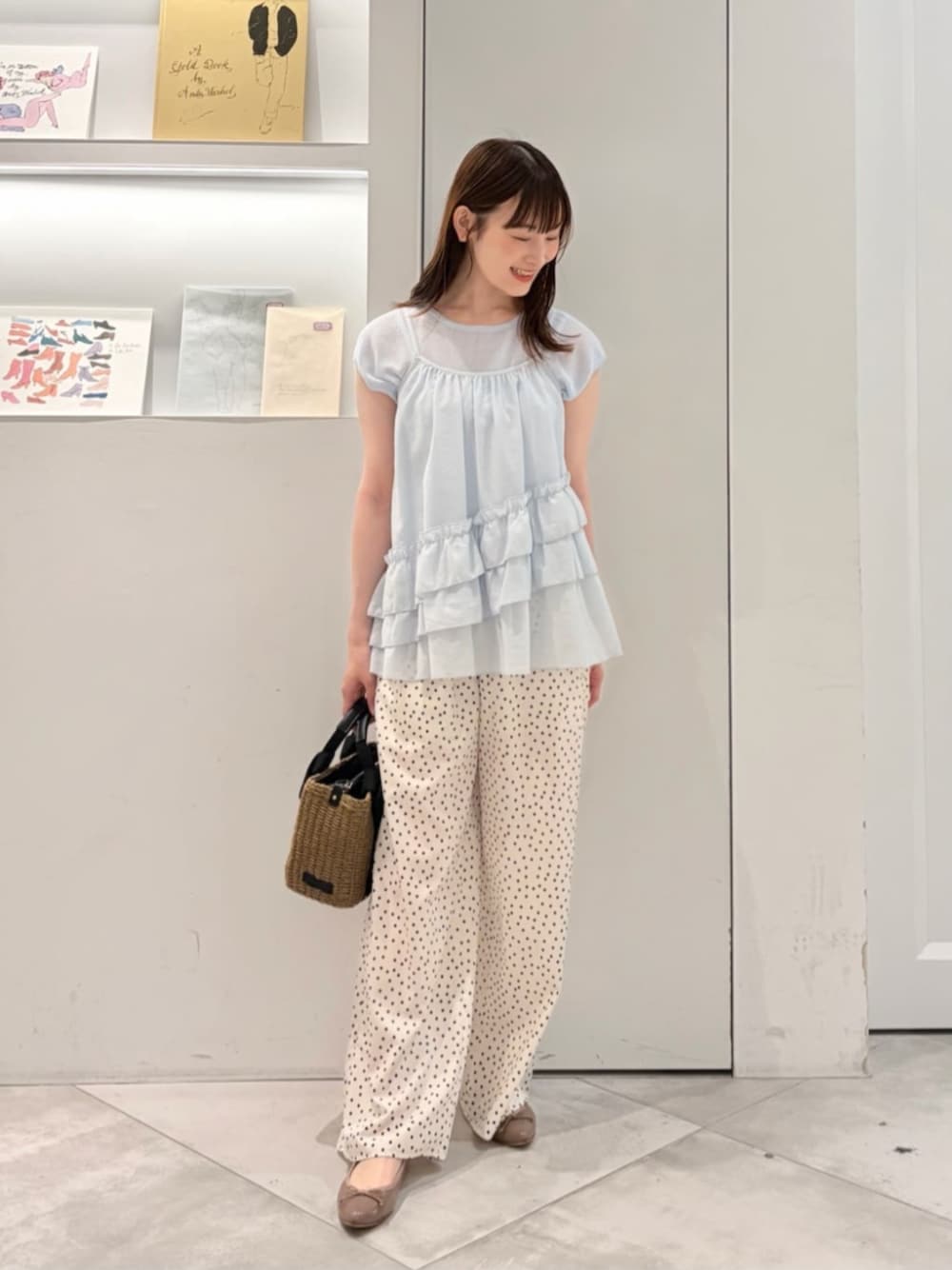 ブルー系のニット/セーター、ホワイト系のその他パンツ、ブラック系のかごバッグを着用したレディースの夏コーディネートの1枚目の写真