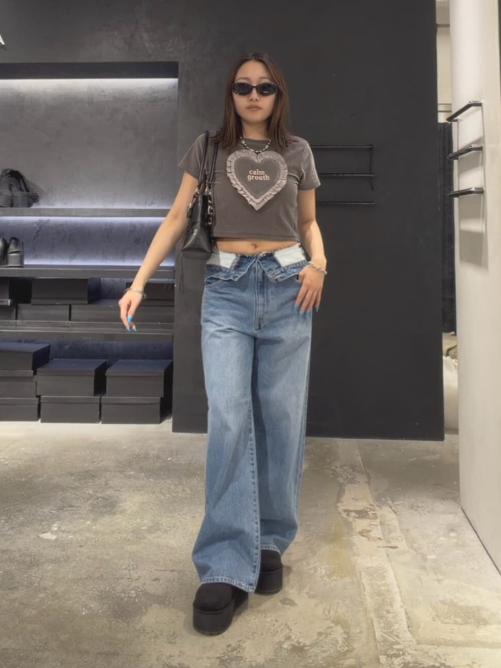 グレー系のTシャツ/カットソー、ブルー系のデニムパンツ、ブラック系のスリッポンを着用したレディースの夏コーディネートの1枚目の写真