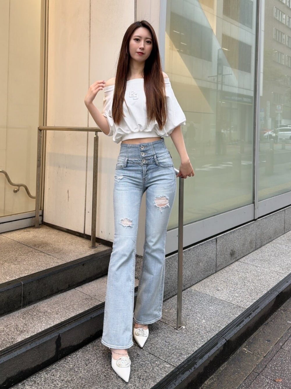 ブルー系のデニムパンツ、ホワイト系のパンプス、ホワイト系のTシャツ/カットソーを着用したレディースの春コーディネートの1枚目の写真